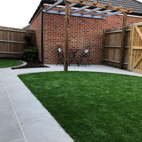 modern back garden layout with semi circular lawn and timber pergola