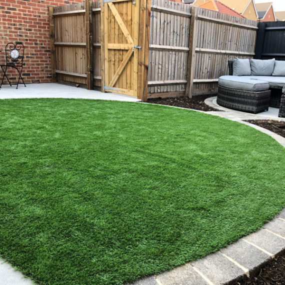 artificial grass lawn with circular seating area in the background