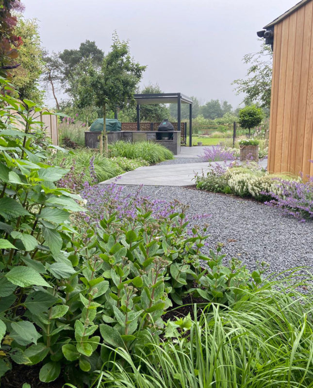 garden path in grey gravel leading to porcelain patio and outdoor kitchen