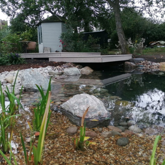 pond with floating deck and summerhouse in the background