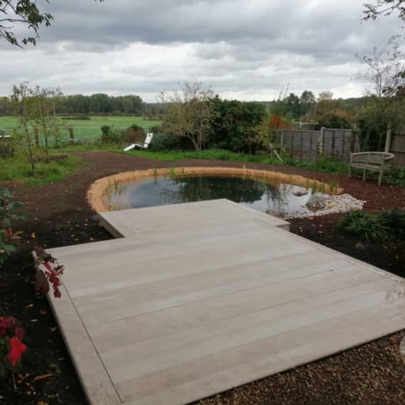 large area of composite decking leading to pond with views over wider countryside