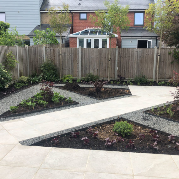 new build garden with diagonal porcelain paved path and triangular planting beds