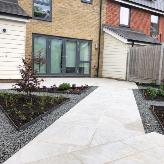 smart cream porcelain pathway edged with grey aggregate and leading towards house