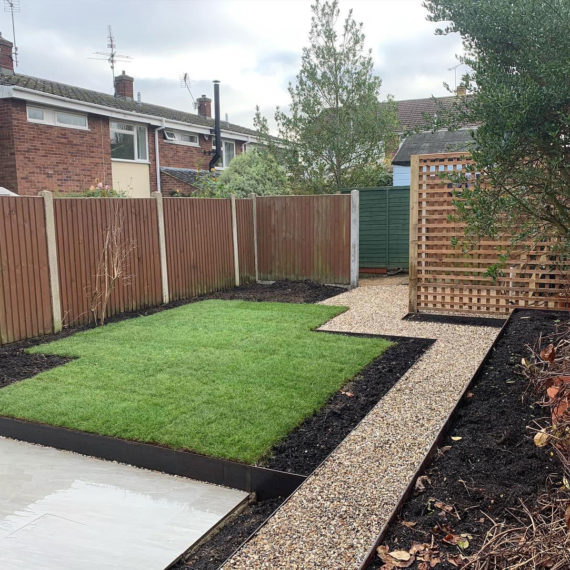 back garden with gravel path, lawns and screen for shed