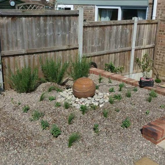 coastal themed garden with ball shaped water feature