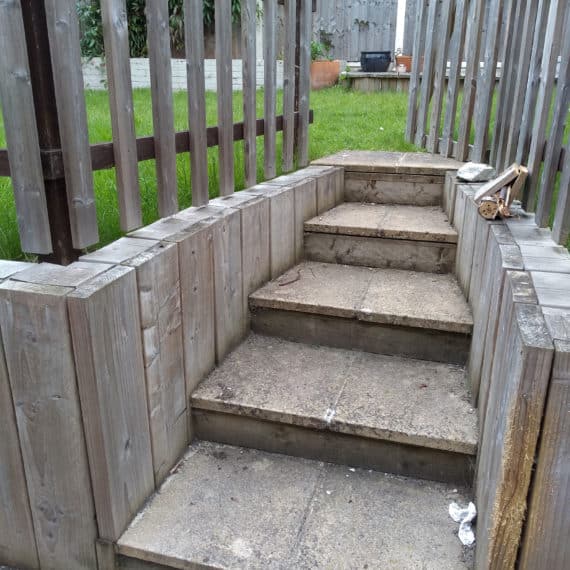 Old and unsafe garden steps enclosed by timber picket fencing