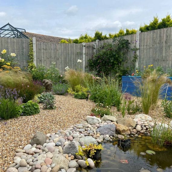 Shallow pool in gravel garden with pretty pebble border