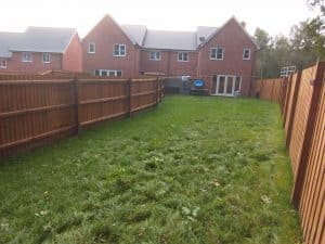 Long thin newbuild garden with timber fence and grass lawn