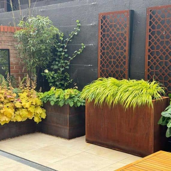 arrangement of metal planters in small courtyard garden