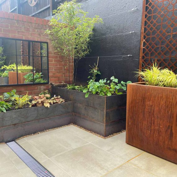 A selection of metal planters to create interest in a paved garden