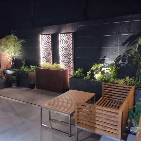 paved garden designed by Tapestry Design Studios with subtle evening lighting