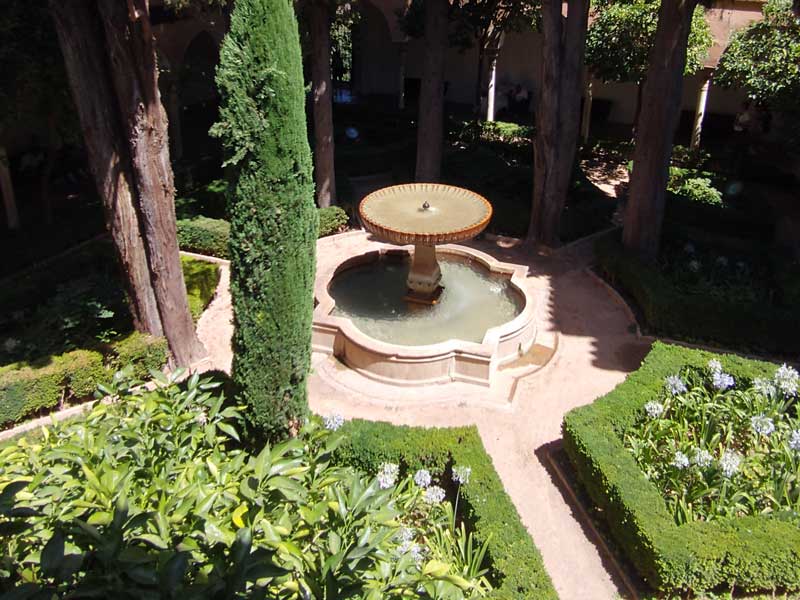 Cool shaded garden with fountain in the Alhambra gardens in Spain
