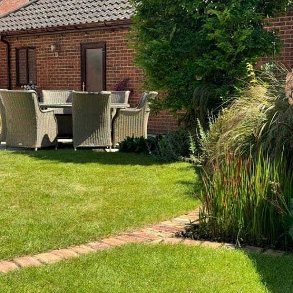 juxtaposition of two circular lawns with pretty planting to curved edges