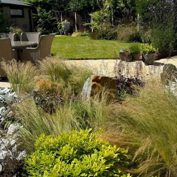 water feature in pretty back garden surrounded by mixed textural planting